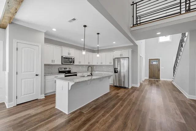 a kitchen with white cabinets and stainless steel appliances