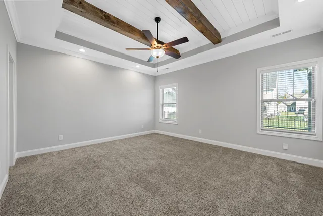 en empty room with windows and ceiling fan