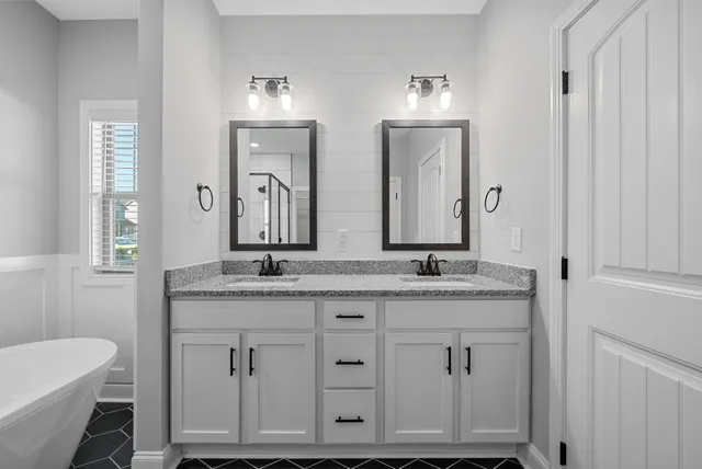 a bathroom with double vanity sinks and a mirror