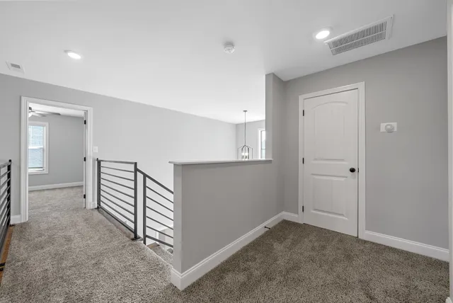 a view of a hallway with entryway and stairs