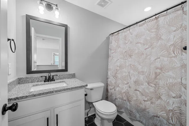 a bathroom with a granite countertop sink toilet and shower