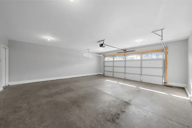 an empty room with ceiling fan and window