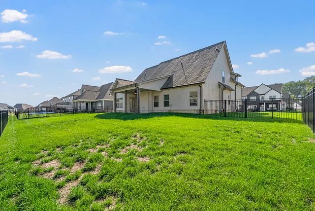a view of a house with a big yard and large trees