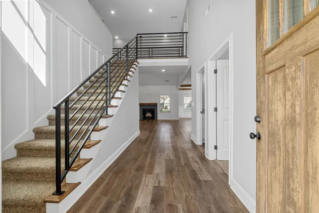 a view of a hallway with wooden floor and staircase