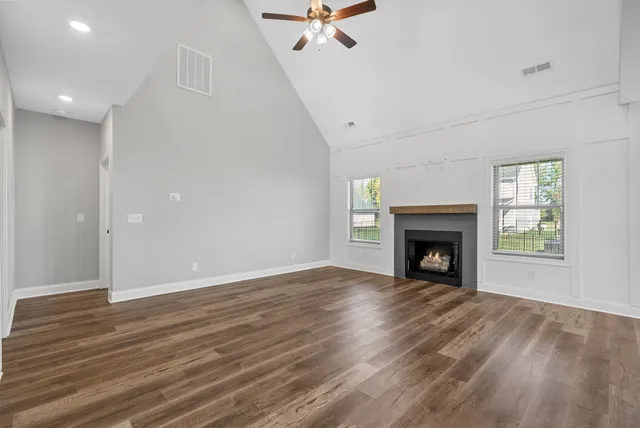 a view of an empty room with a fireplace and a window