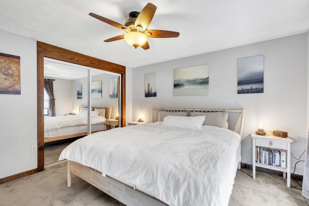 583 Main Road Chesterfield, MA 01012 - Photo 9 of 21 a bedroom with a large bed a flat screen tv and a chandelier