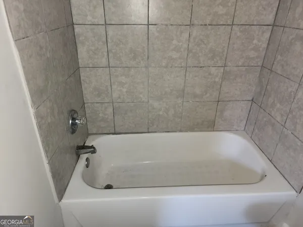 a view of an empty room with a fireplace and a window