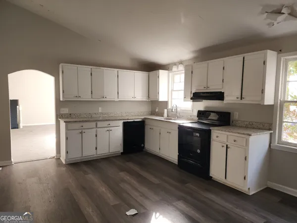 a kitchen with granite countertop white cabinets and white appliances