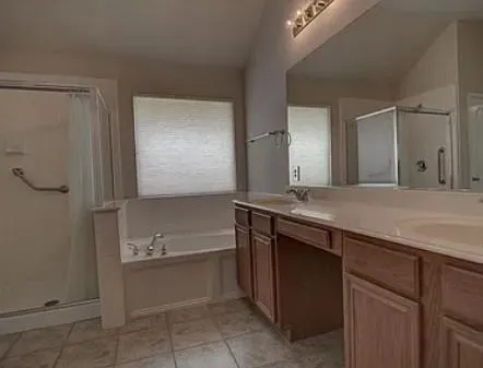 a bathroom with a granite countertop sink mirror and a bathtub