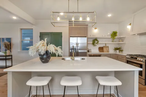 a kitchen with stainless steel appliances a table chairs and stove