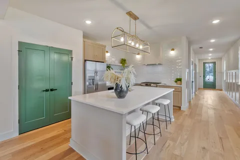 a view of a livingroom and dining room with furniture window and wooden floor