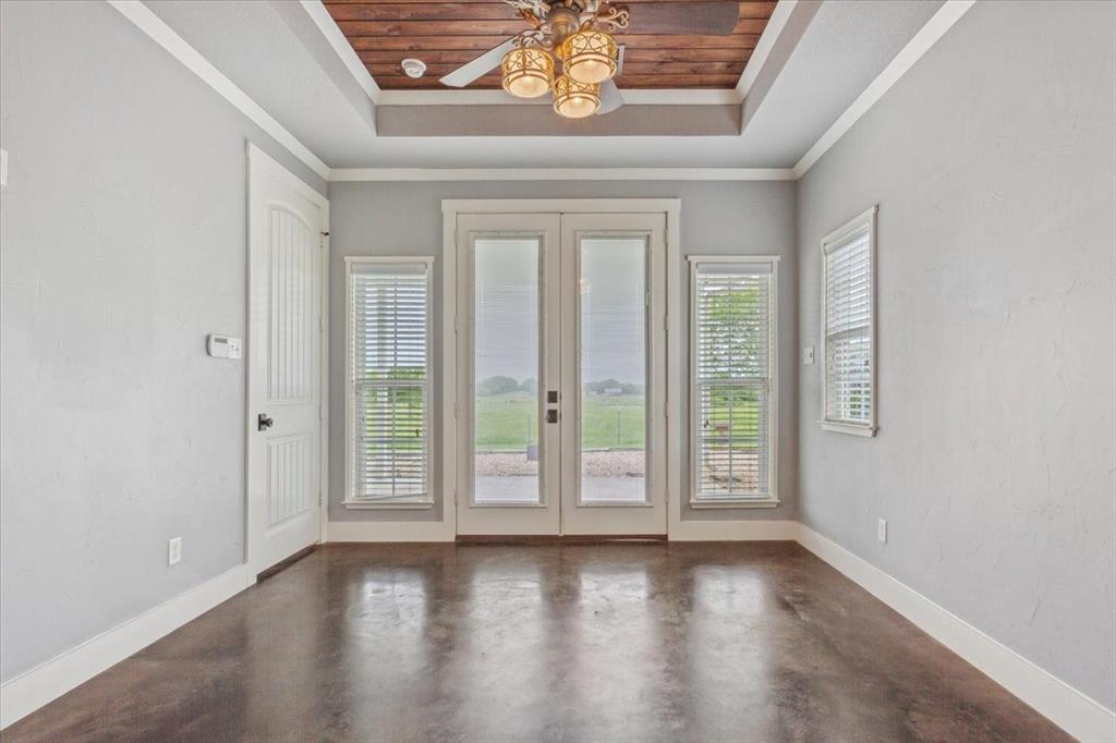 259 County Road 149 Riesel, TX 76682 - Photo 16 of 40 Entryway with french doors, a raised ceiling, concrete floors, ceiling fan, and ornamental molding