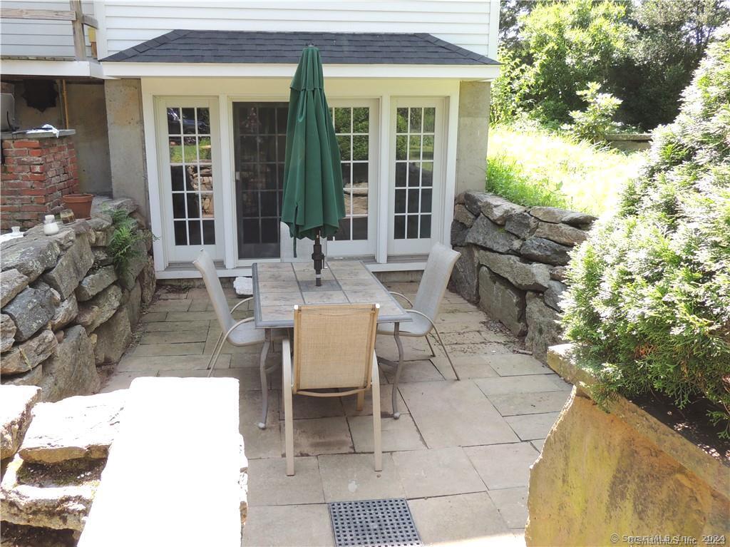 164 Mill Plain Road, Unit 1 Branford, CT 06405 - Photo 1 of 1 a view of a patio with table and chairs and potted plants