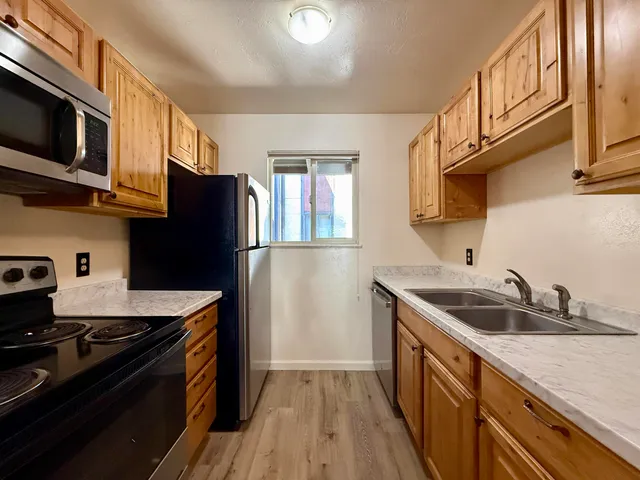 a kitchen with stainless steel appliances granite countertop a sink stove and refrigerator
