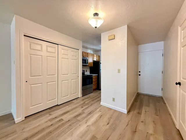 an empty room with wooden floor and closet area