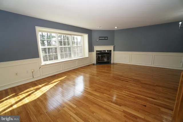 a view of a room with wooden floor and white walls