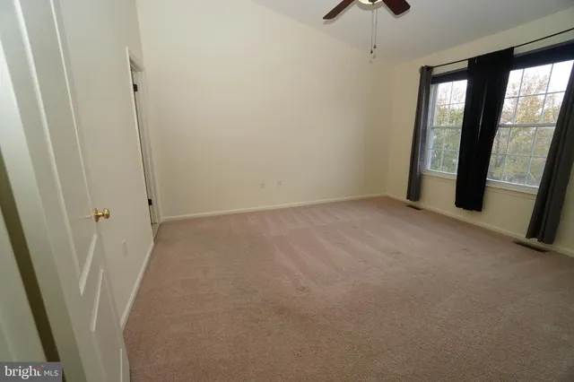 an empty room with windows and closet