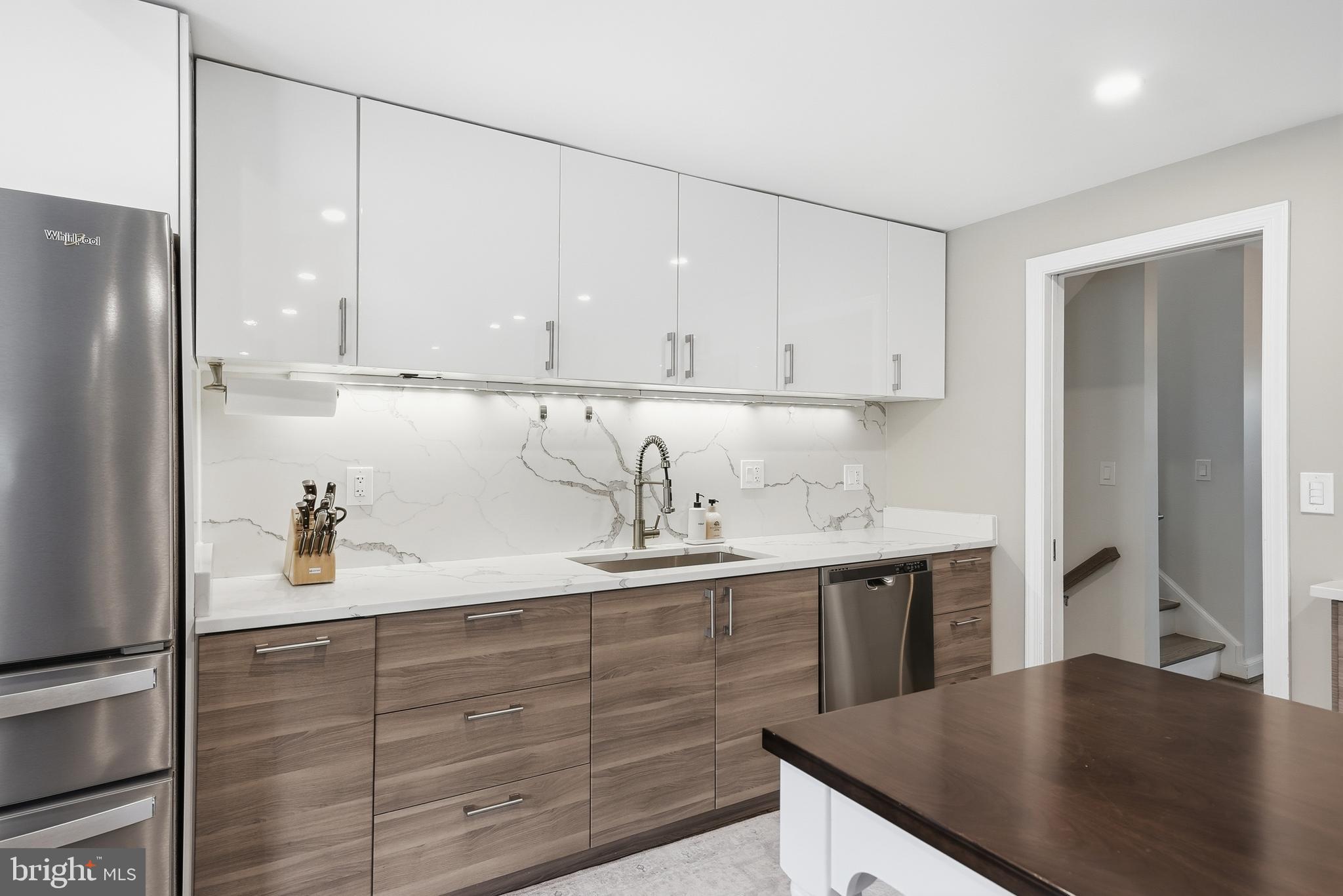 10712 Lockland Road Potomac, MD 20854 - Photo 20 of 66 a kitchen with a sink dishwasher a refrigerator and cabinets with wooden floor