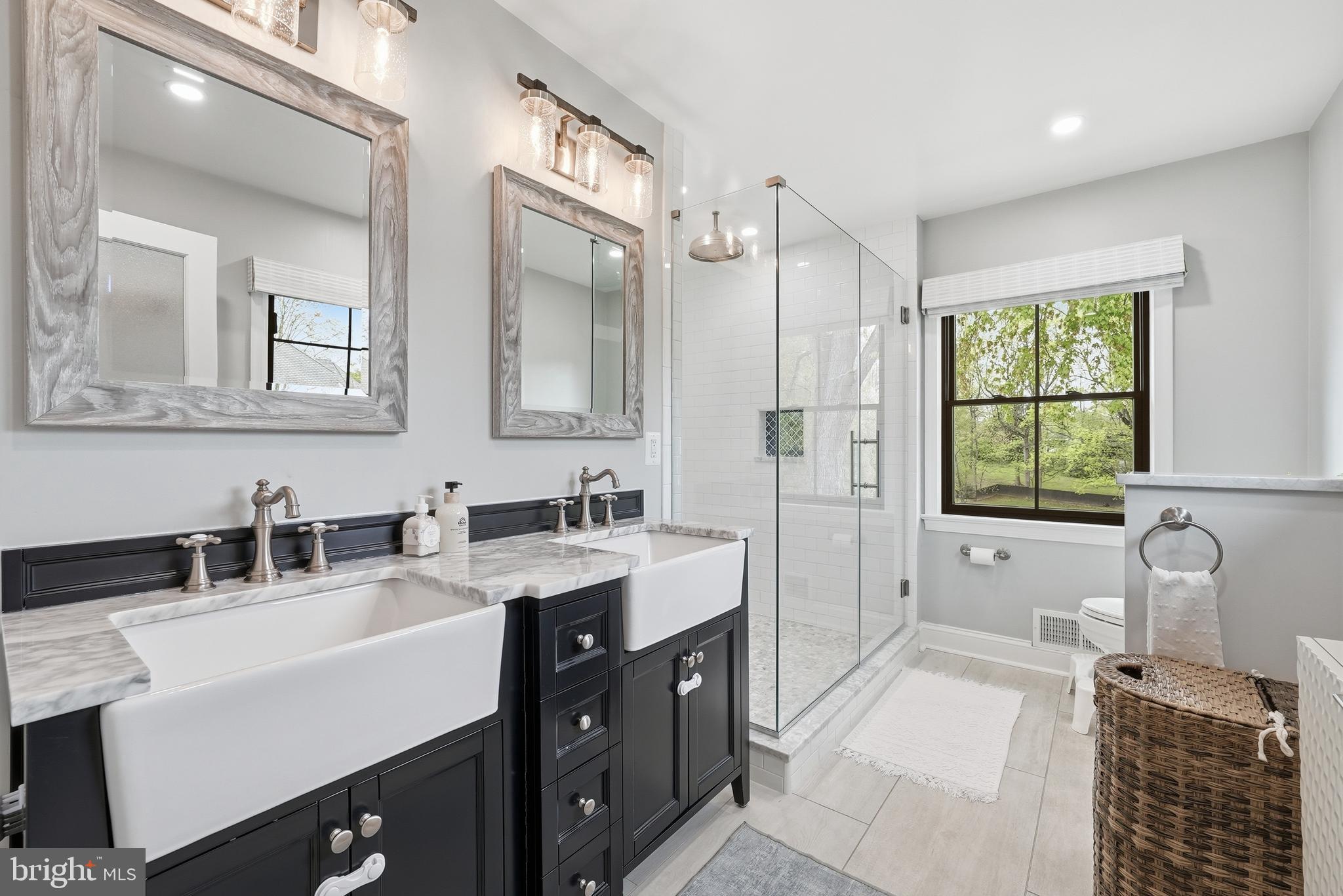 10712 Lockland Road Potomac, MD 20854 - Photo 29 of 66 a bathroom with a sink double vanity granite tub shower and a mirror
