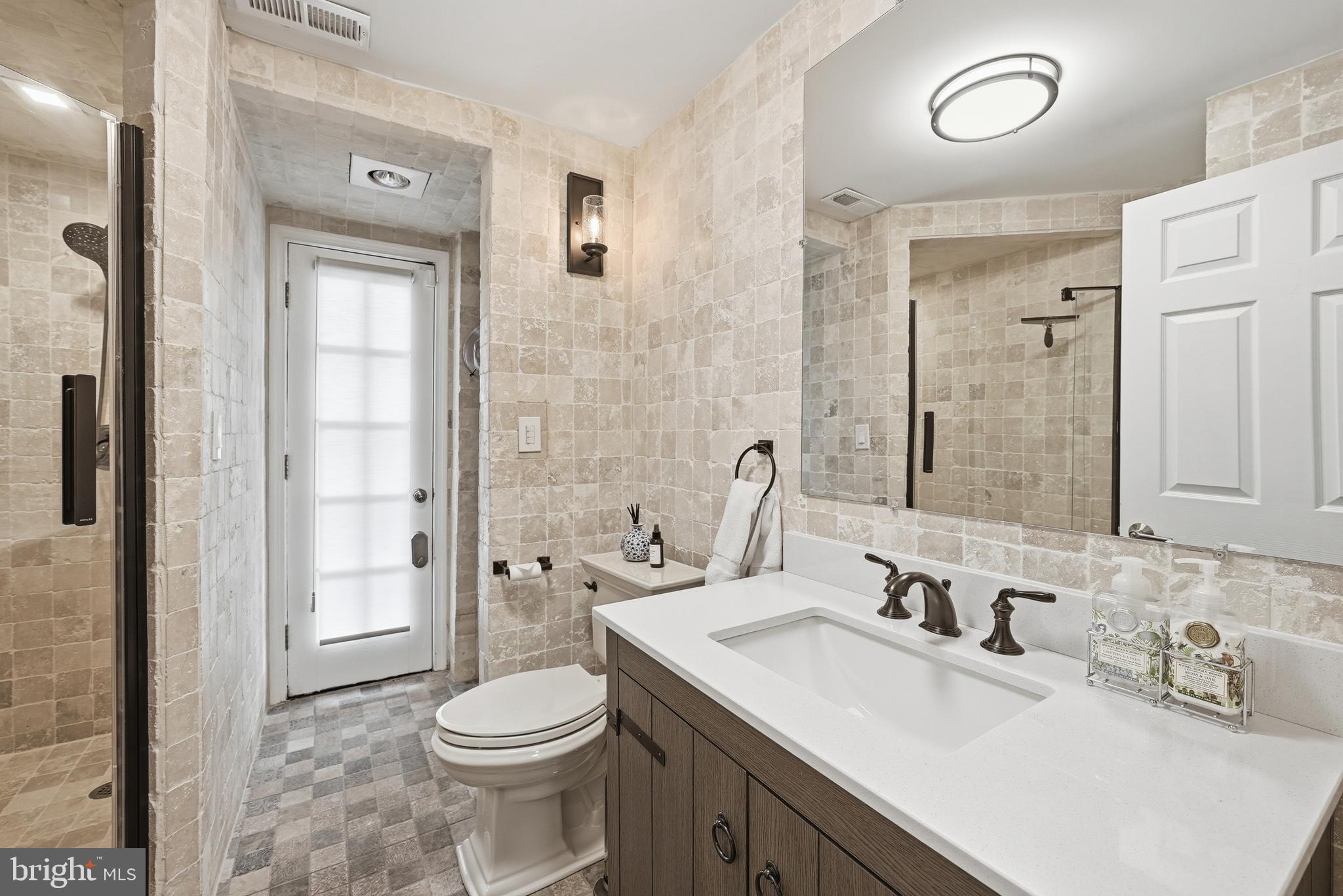 10712 Lockland Road Potomac, MD 20854 - Photo 47 of 66 a bathroom with a sink vanity mirror and toilet