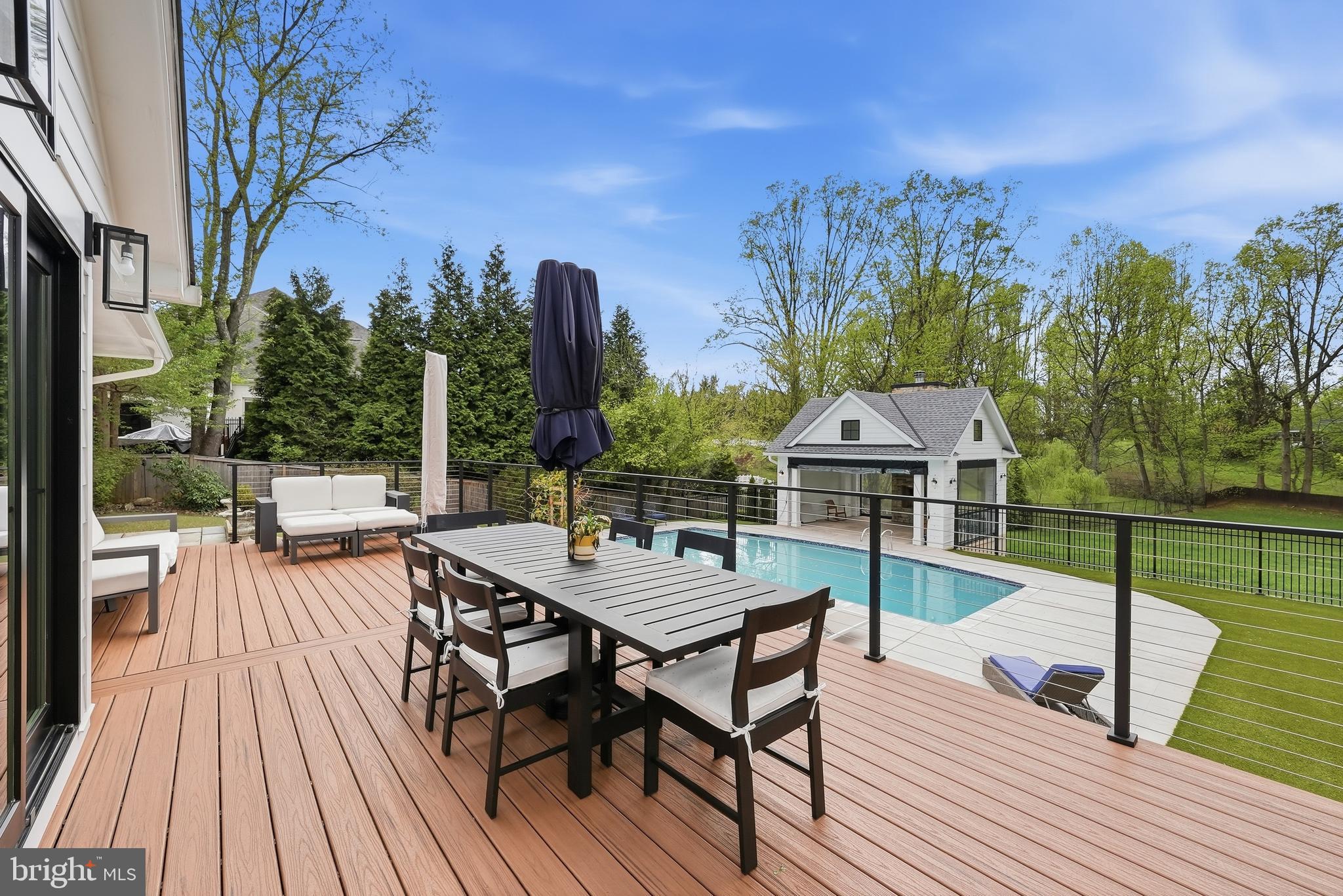 10712 Lockland Road Potomac, MD 20854 - Photo 54 of 66 a view of a roof deck with table and chairs a barbeque with wooden floor and fence