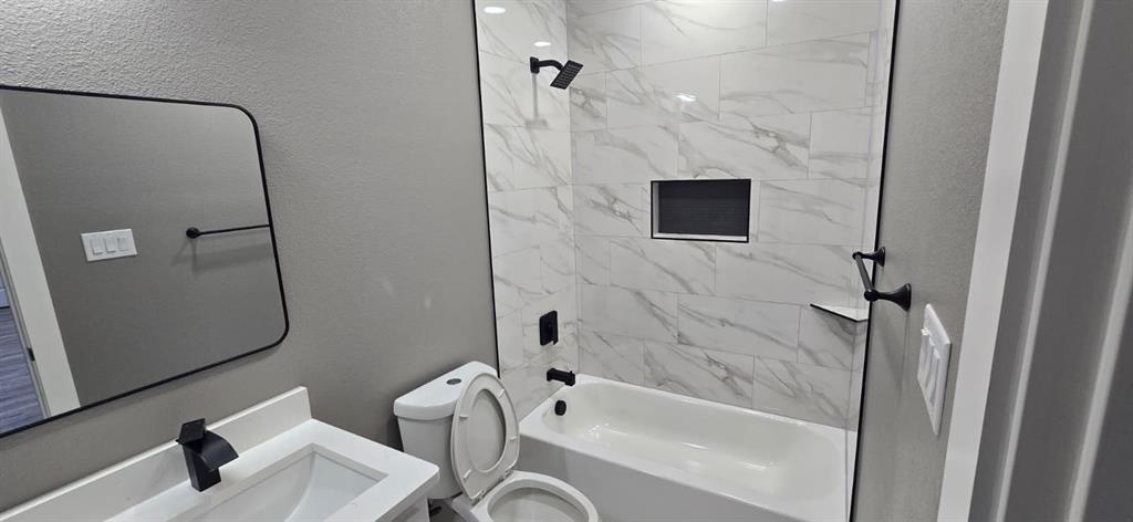 805 Fletcher Street Gainesville, TX 76240 - Photo 18 of 21 a bathroom with a bathtub and a shower