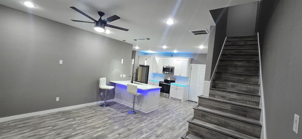 805 Fletcher Street Gainesville, TX 76240 - Photo 5 of 21 a view of a room with stairs and wooden floor