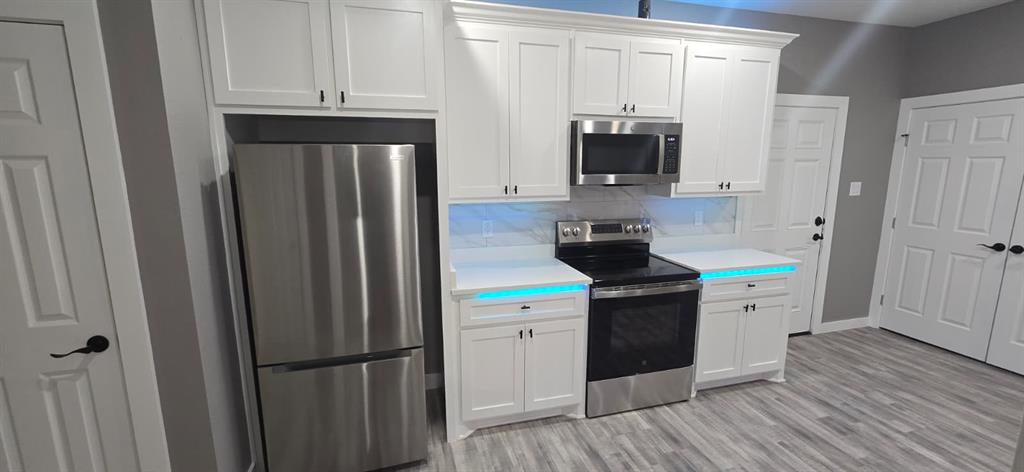805 Fletcher Street Gainesville, TX 76240 - Photo 6 of 21 a kitchen with a refrigerator and a stove top oven