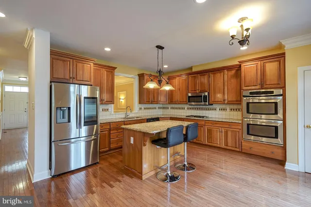 a kitchen with stainless steel appliances kitchen island a chandelier