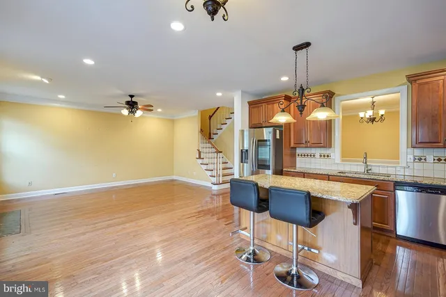a kitchen with stainless steel appliances kitchen island granite countertop a stove top oven and cabinets