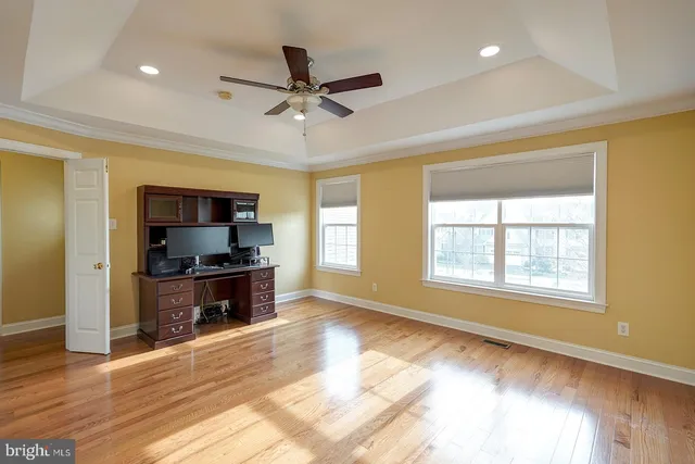 a view of a livingroom with kitchen space and wooden floor
