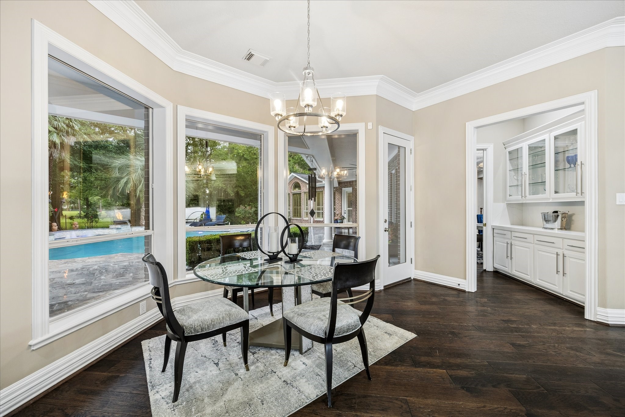 35 North Regent Oak Spring, TX 77381 - Photo 13 of 43 Bathed in natural light, this inviting breakfast area offers picturesque views of the pool and beautifully landscaped backyard through expansive windows. Whether enjoying your morning coffee or gathering for a casual meal, you'll appreciate the peaceful setting and inspiring views that make every day feel a little more special.