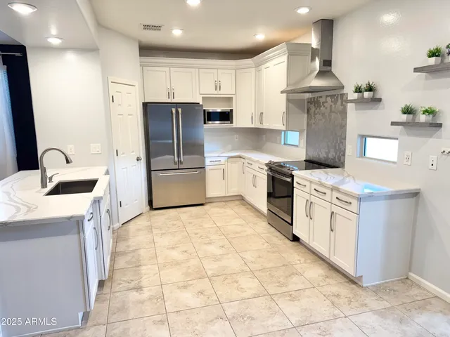 a kitchen with stainless steel appliances granite countertop a sink a stove a refrigerator and a oven