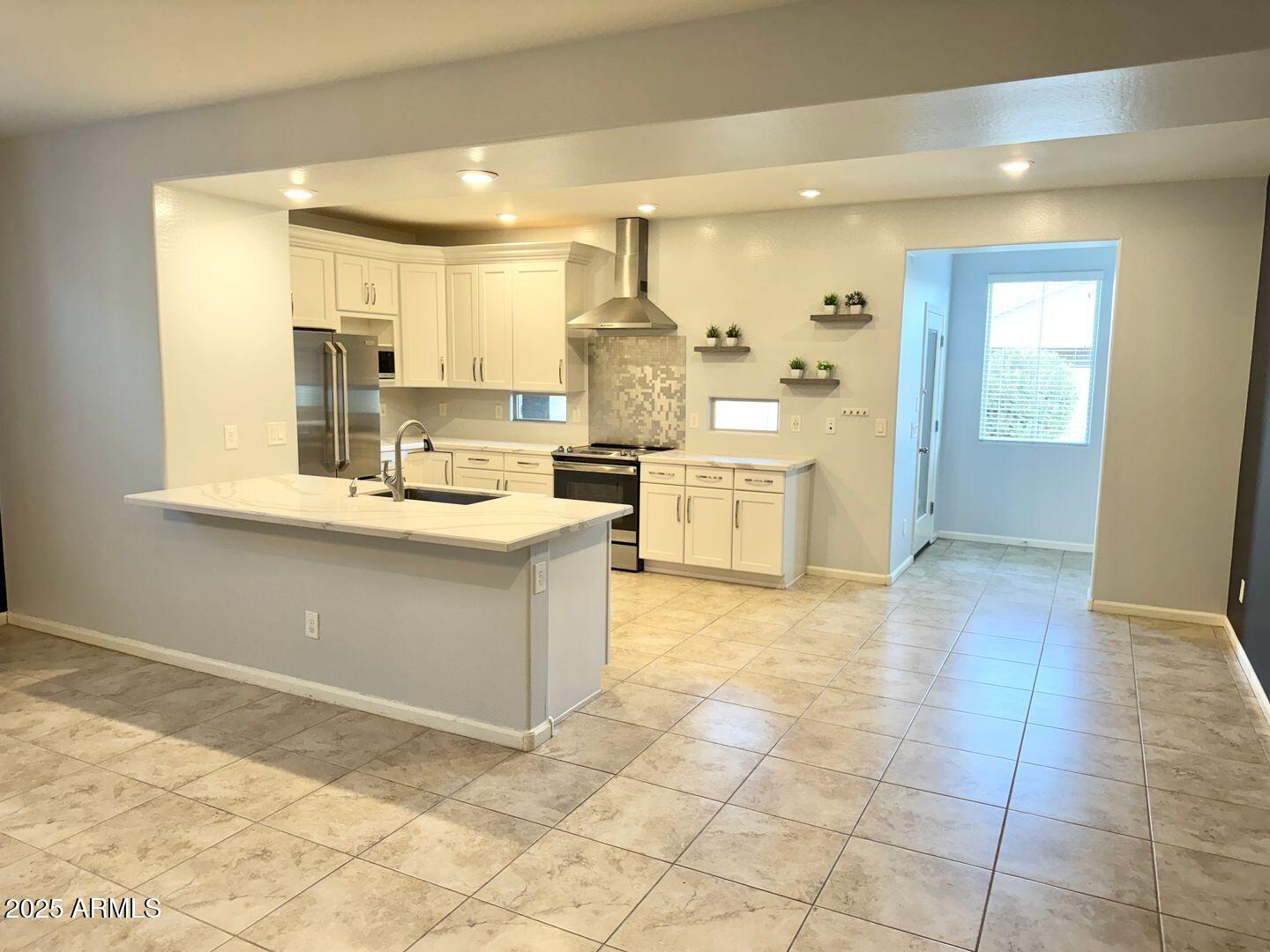 3870 East Balsam Drive Chandler, AZ 85286 - Photo 7 of 39 a kitchen with granite countertop a stove a sink and a refrigerator