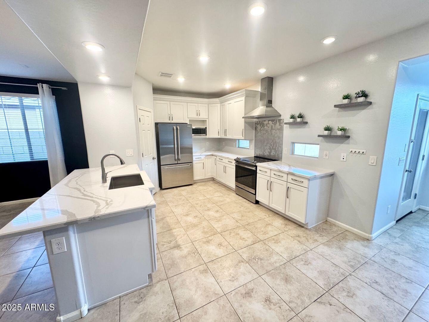 3870 East Balsam Drive Chandler, AZ 85286 - Photo 8 of 39 a large kitchen with stainless steel appliances kitchen island granite countertop a sink and cabinets