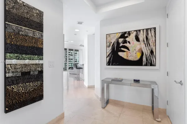 a view of a hallway with wooden floor and furniture