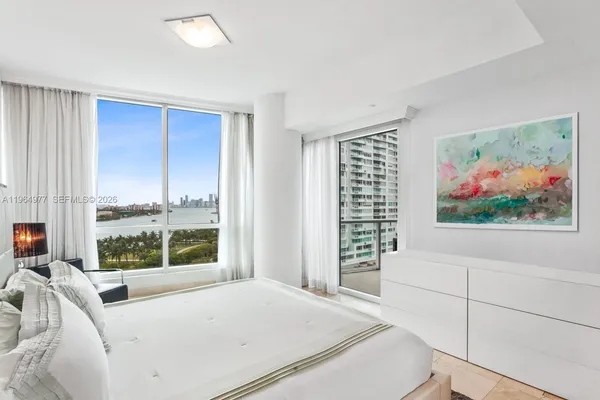 a bedroom with a bed and a large window