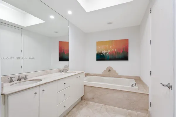 a bathroom with 2 sink tub and a mirror