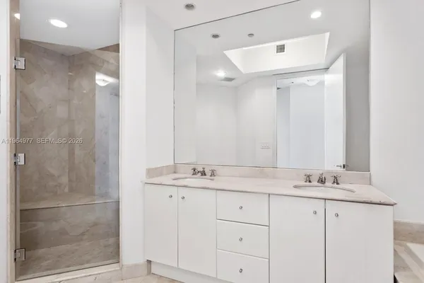 a bathroom with a shower sink and mirror