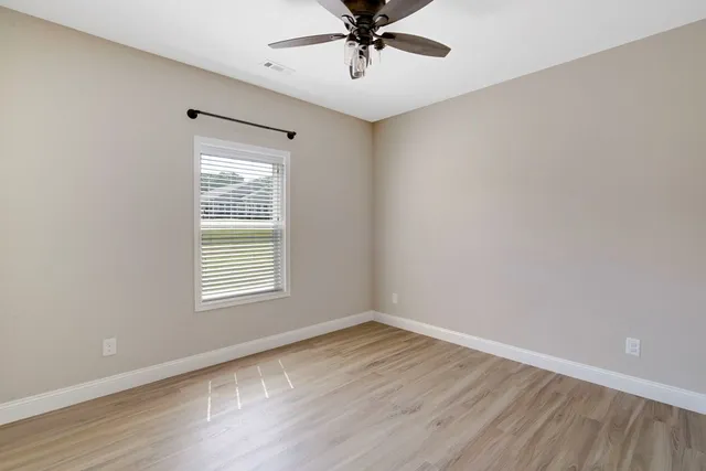 a view of a big room with wooden floor and windows