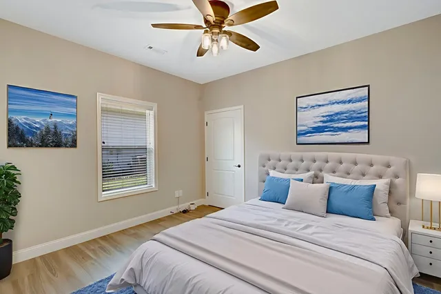 a bedroom with a bed and a painting on the wall