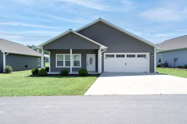 a front view of a house with a yard and garage