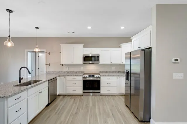 a kitchen with stainless steel appliances granite countertop a sink stove and refrigerator