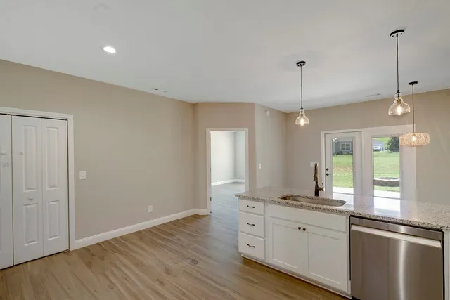 a view of a kitchen island a chandelier and wooden floor