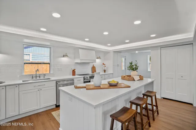 a kitchen with a sink cabinets and wooden floor