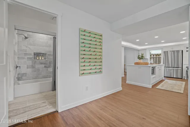 a view of a kitchen with wooden floor and a window