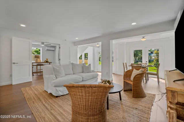 a living room with furniture and a dining table with wooden floor