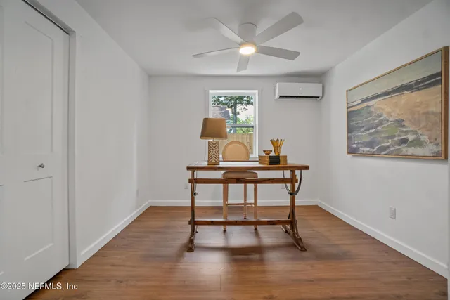 a view of a workspace with furniture window and wooden floor