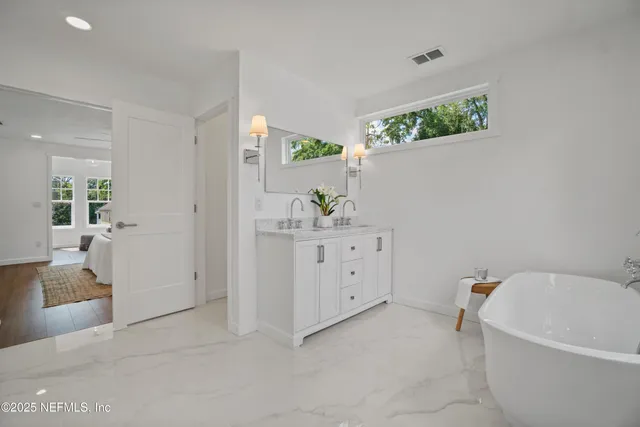 a bathroom with a bathtub sink and mirror
