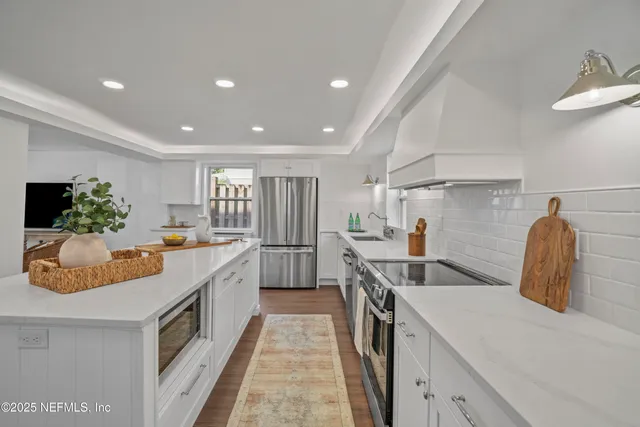 a kitchen with stainless steel appliances granite countertop a sink a stove and a refrigerator
